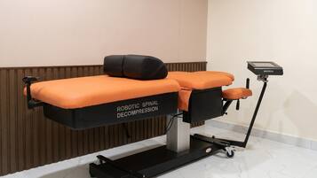 Une table d’examen médical équipée d’un appareil robotisé de décompression de la colonne vertébrale.