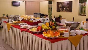 A buffet setup with various food items and a large pot, likely for cooking or heating food.