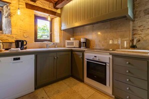 Cozinha compacta com lava-louças, forno e micro-ondas na bancada.