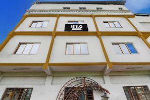 A multi-story hotel with a sign reading 'HOTEL' and 'Company Serviced.' - Hotel O Botanical Garden  (Howrah)