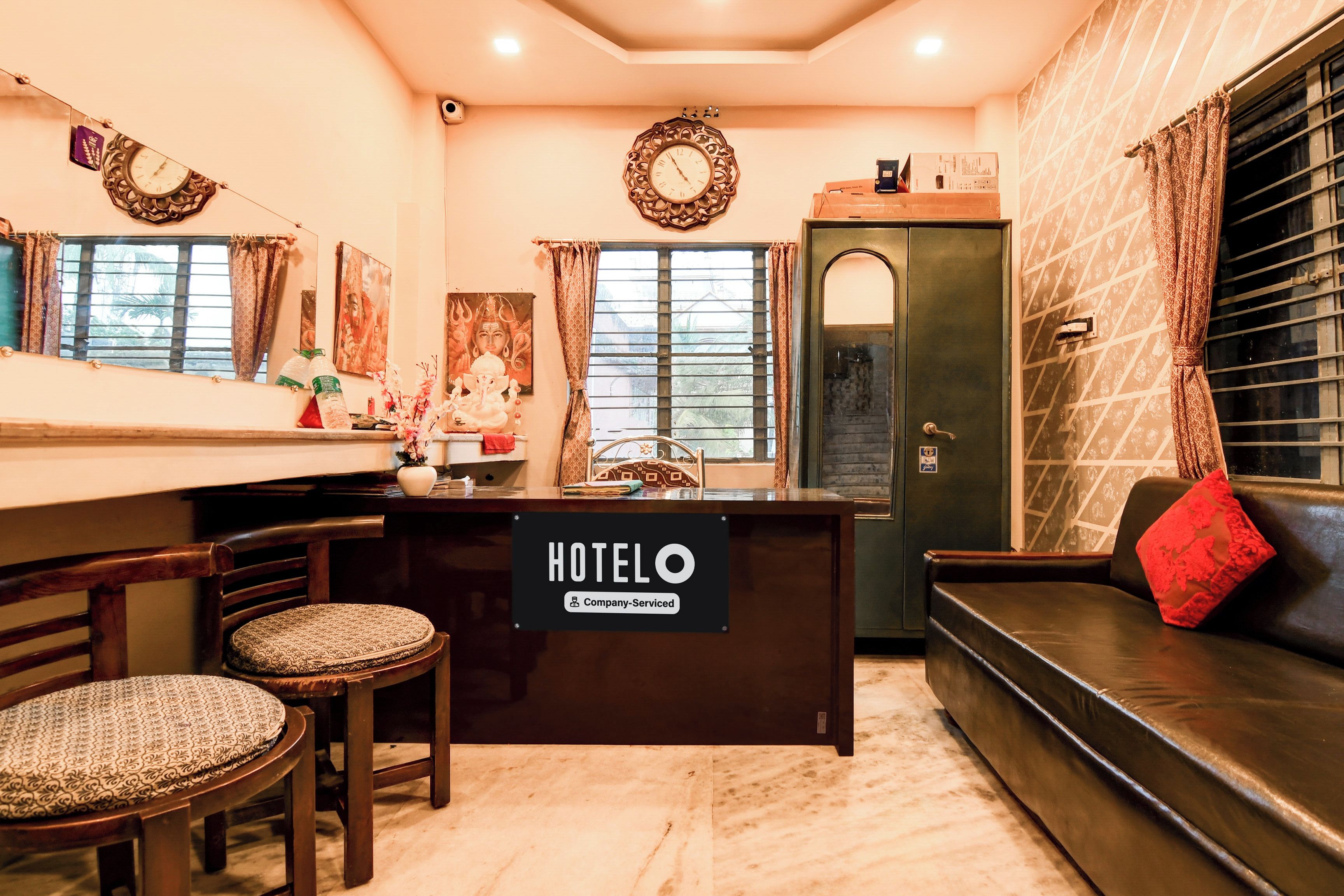 Un vestíbulo de hotel con mostrador de recepción, zona de estar y detalles decorativos.