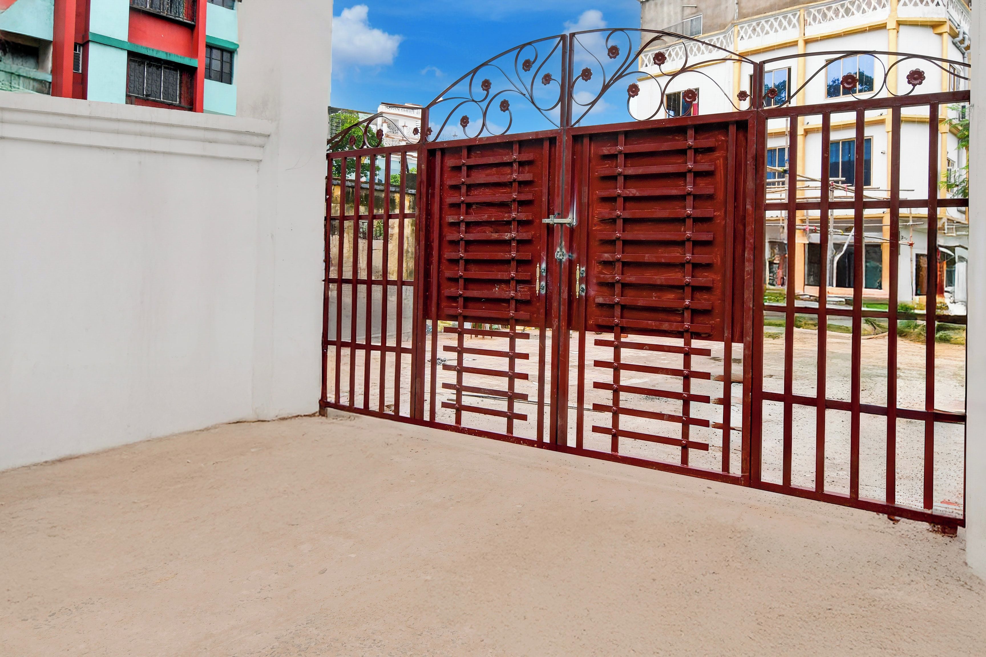 A gated entrance with a metal gate and a white wall.