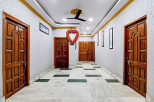 A hallway with marble flooring, wooden doors, and a ceiling fan.