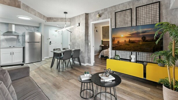 A modern living space with a kitchen, dining area, and seating area. - 1BR ADA apartment | 5 min to Epic Universe (Orlando)