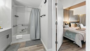 A modern bathroom with a shower, toilet, and sink. - 1BR ADA apartment | 5 min to Epic Universe (Orlando)