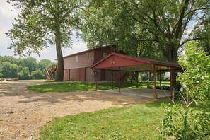 A two-story building with a covered patio area. - Riverfront Property Near Downtown Pella with Game Room, Fire Pit, and Yard Games (Pella)