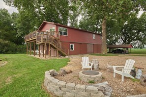 A two-story house with a deck, a fire pit, and outdoor seating. - Riverfront Property Near Downtown Pella with Game Room, Fire Pit, and Yard Games (Pella)
