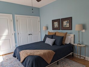 A bedroom with a bed, two doors, two wall-mounted lamps, and a patterned rug. - Midtown 4BR • 3 Baths • Screened Porch • Near FSU (Tallahassee)