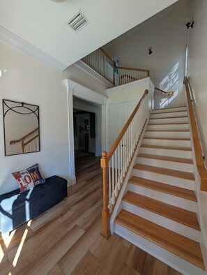 A staircase with wooden steps and white railings, leading to an upper floor. - Walkable Midtown Retreat-Spacious 4BR/3BA & Screened Porch- Near FSU & Downtown (Tallahassee)