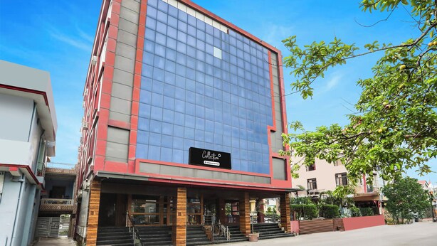 Um edifício moderno com fachada de vidro, uma placa indicando serviço da empresa e uma escadaria que leva à entrada.