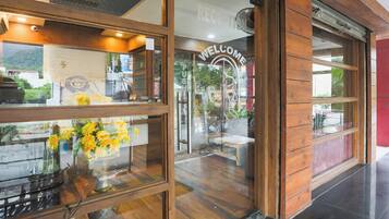 A reception area with a wooden interior, a reception desk, and a 'WELCOME' sign.