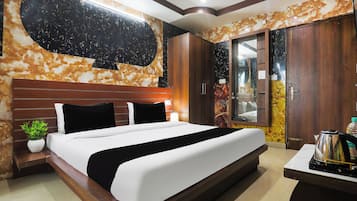 A modern hotel room with a large bed, wooden headboard, and a marble-patterned wall.