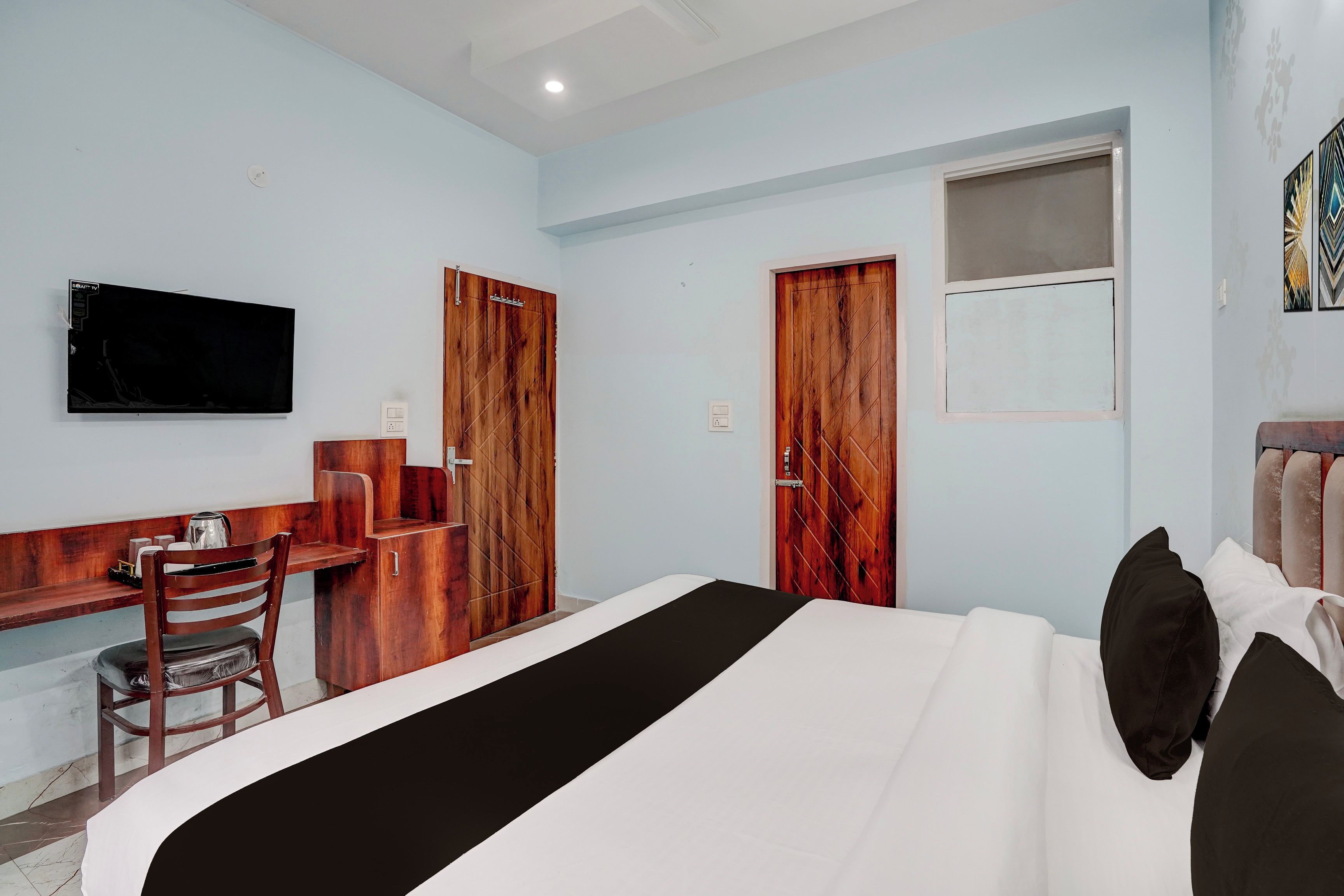 Una habitación de hotel con cama, escritorio, silla y televisor.