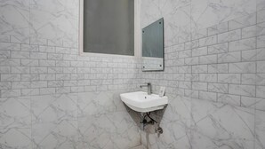 A bathroom with a white sink, a mirror, and a window. - Super Hotel O by OYO Fountain Chowk (Chandigarh)