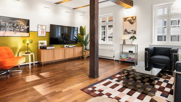 A modern living room with wooden flooring, a television, a sofa, and a coffee table. - Vrbo Property (Bad Hersfeld)