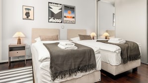 A modern hotel room with two beds, a striped rug, and artwork on the walls. - Vrbo Property (Bad Hersfeld)
