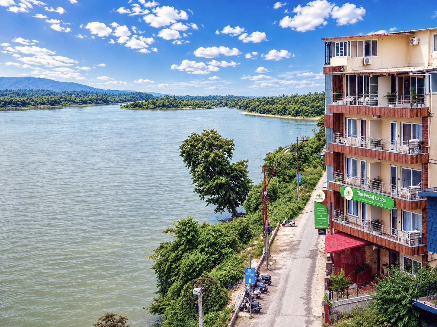 Hotel com vista para o rio, área de estacionamento e placa indicando The Neeraj Ganga.