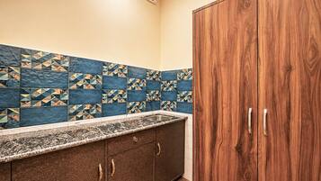 Una cocina con salpicadero de azulejos, armarios de madera y encimera de mármol.