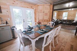 A wooden interior with a dining area, kitchen, and seating space.