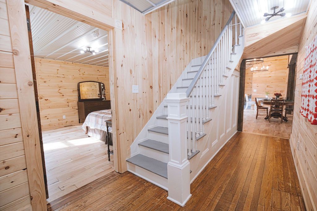 Un interior de madera con una escalera que conduce a un comedor.