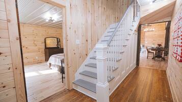 Un interior de madera con una escalera que conduce a un comedor.