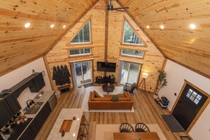 Un loft spacieux avec de hauts plafonds, des murs en bois et de grandes fenêtres.
