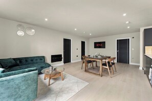 Ein modernes Wohnzimmer mit Sofa, Couchtisch und Esstisch.