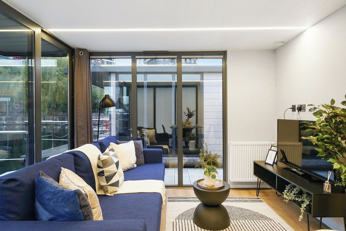 A modern living room with a sofa, a coffee table, and a television.