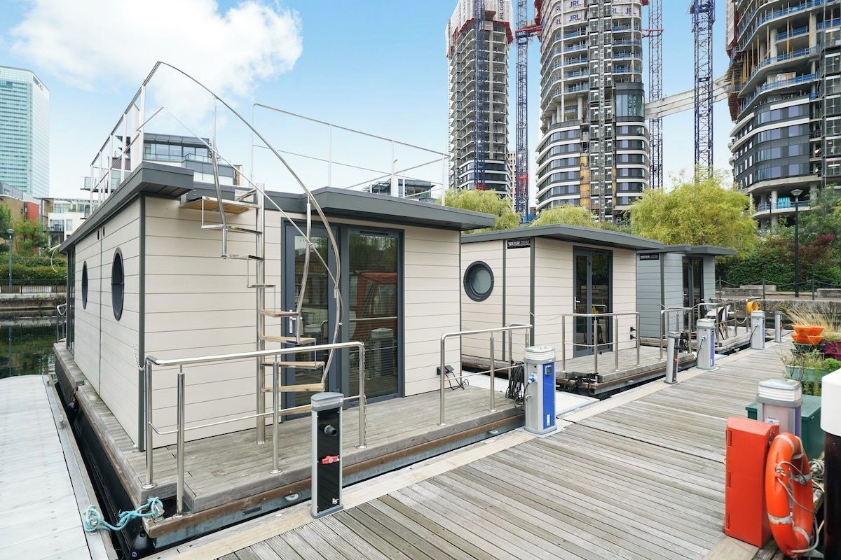 A waterfront property with a dock, a small building with a door and windows, and a lifebuoy.