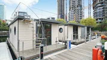 A waterfront property with a dock, a small building with a door and windows, and a lifebuoy.