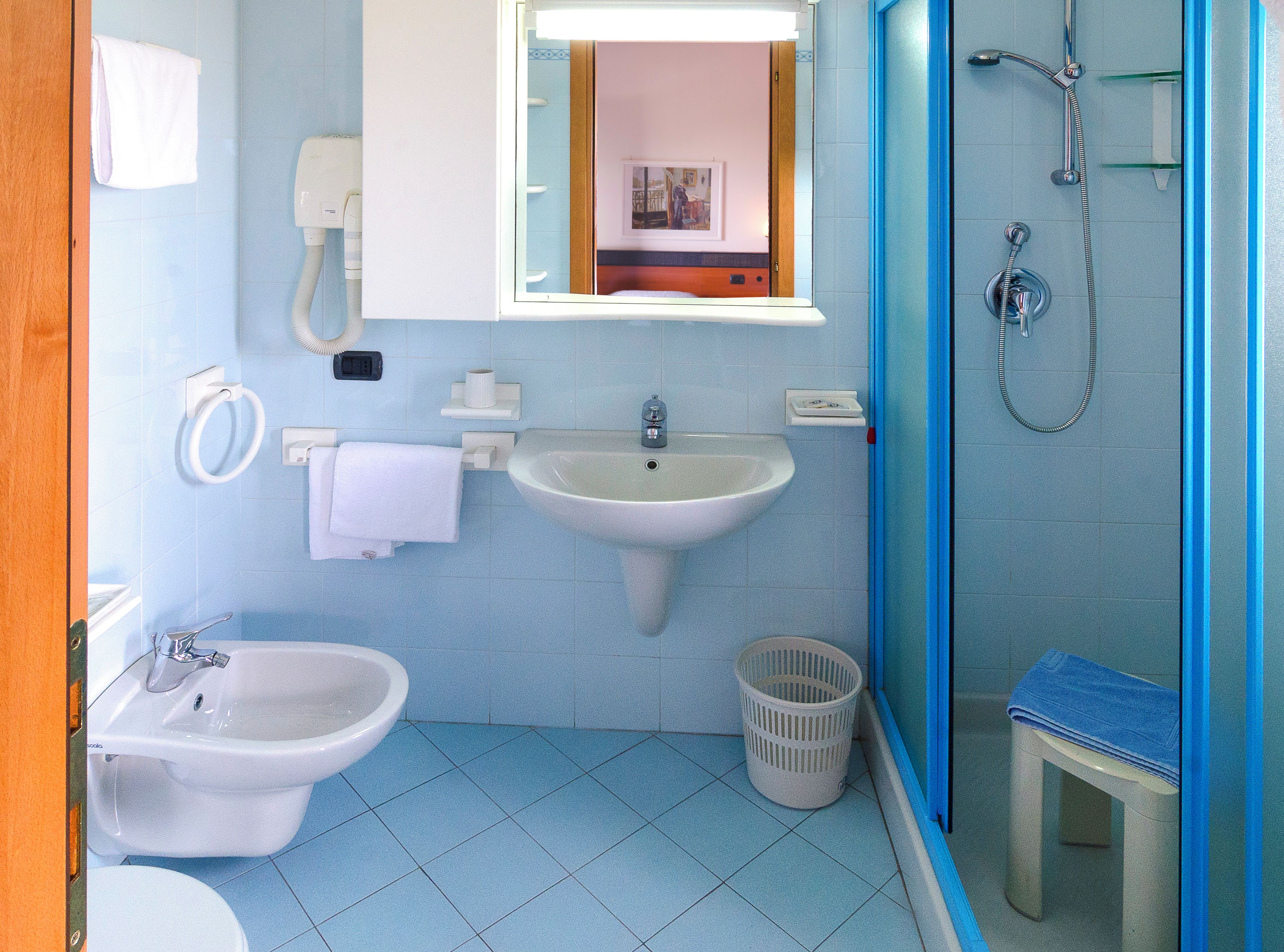 Un baño con lavamanos, bidé y ducha.