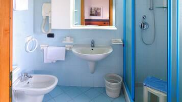 Un baño con lavamanos, bidé y ducha.
