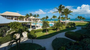 Ein Resort mit Schwimmbad, Palmen und Blick auf den Ozean.