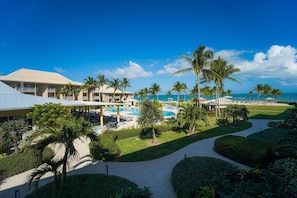 A resort with a swimming pool, palm trees, and a view of the ocean. - Enjoy Ocean Views, Tropical Breezes & Breakfast on Your Island Getaway (West Bay)