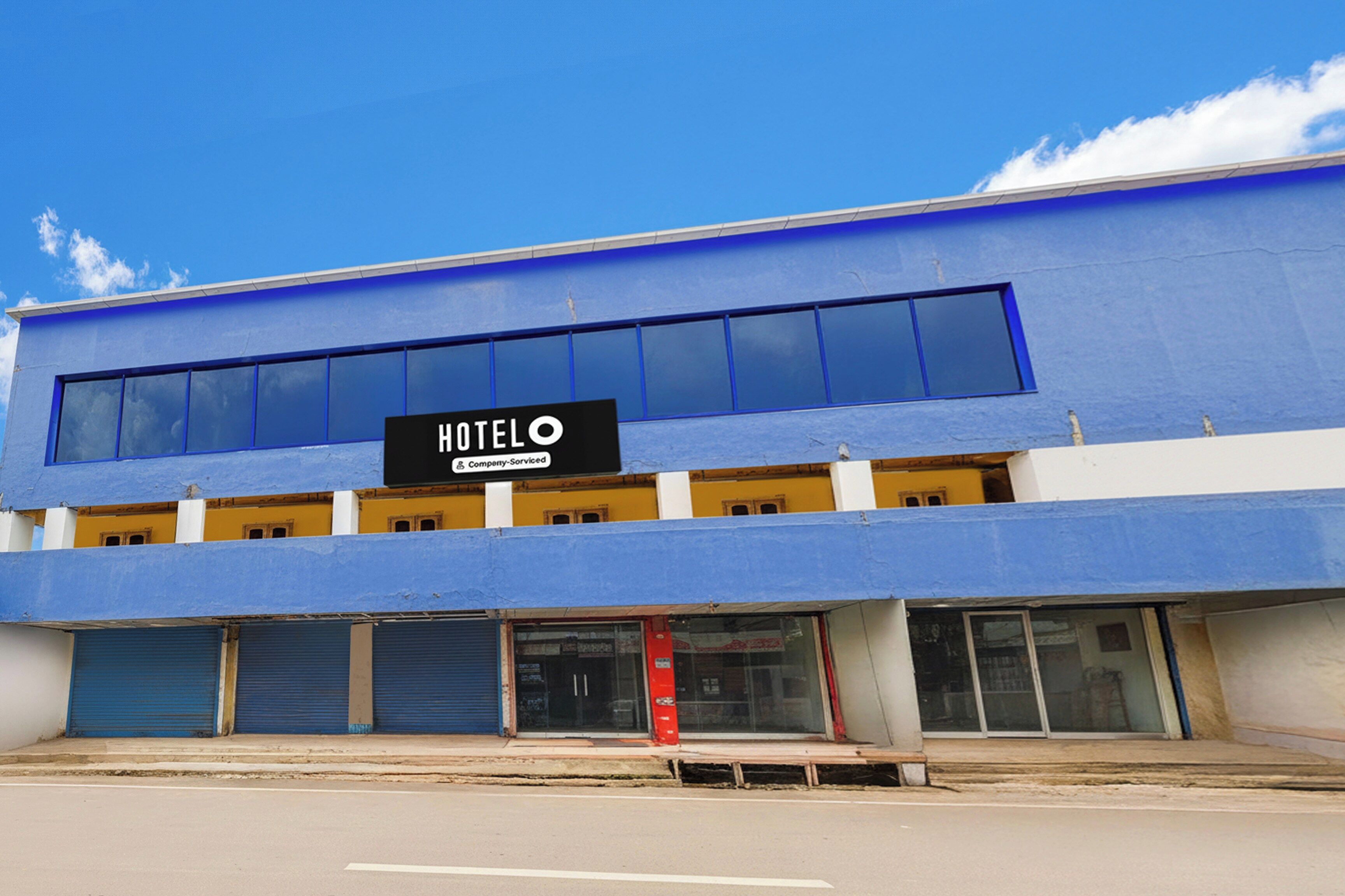 Un edificio azul con un letrero que dice 'HOTEL' y 'Company-Serviced'.