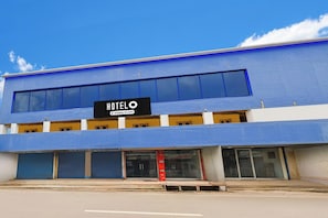 A blue building with a sign that reads 'HOTEL' and 'Company-Serviced.'