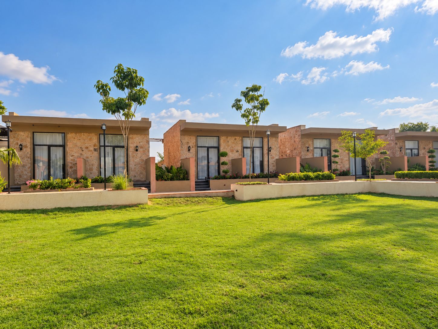 A modern building with a stone facade, multiple windows, and a well-maintained lawn.