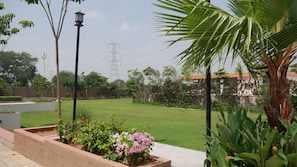 A well-maintained garden with a lawn, various plants, and a street lamp. - Hunaariya Farms (Jaipur)