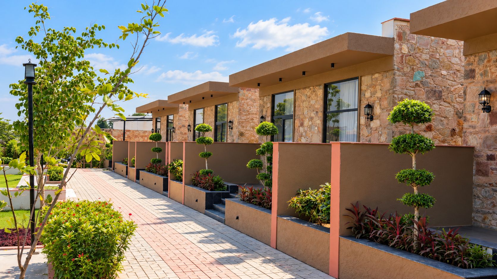 A row of modern buildings with stone facades, large windows, and small trees in planters.