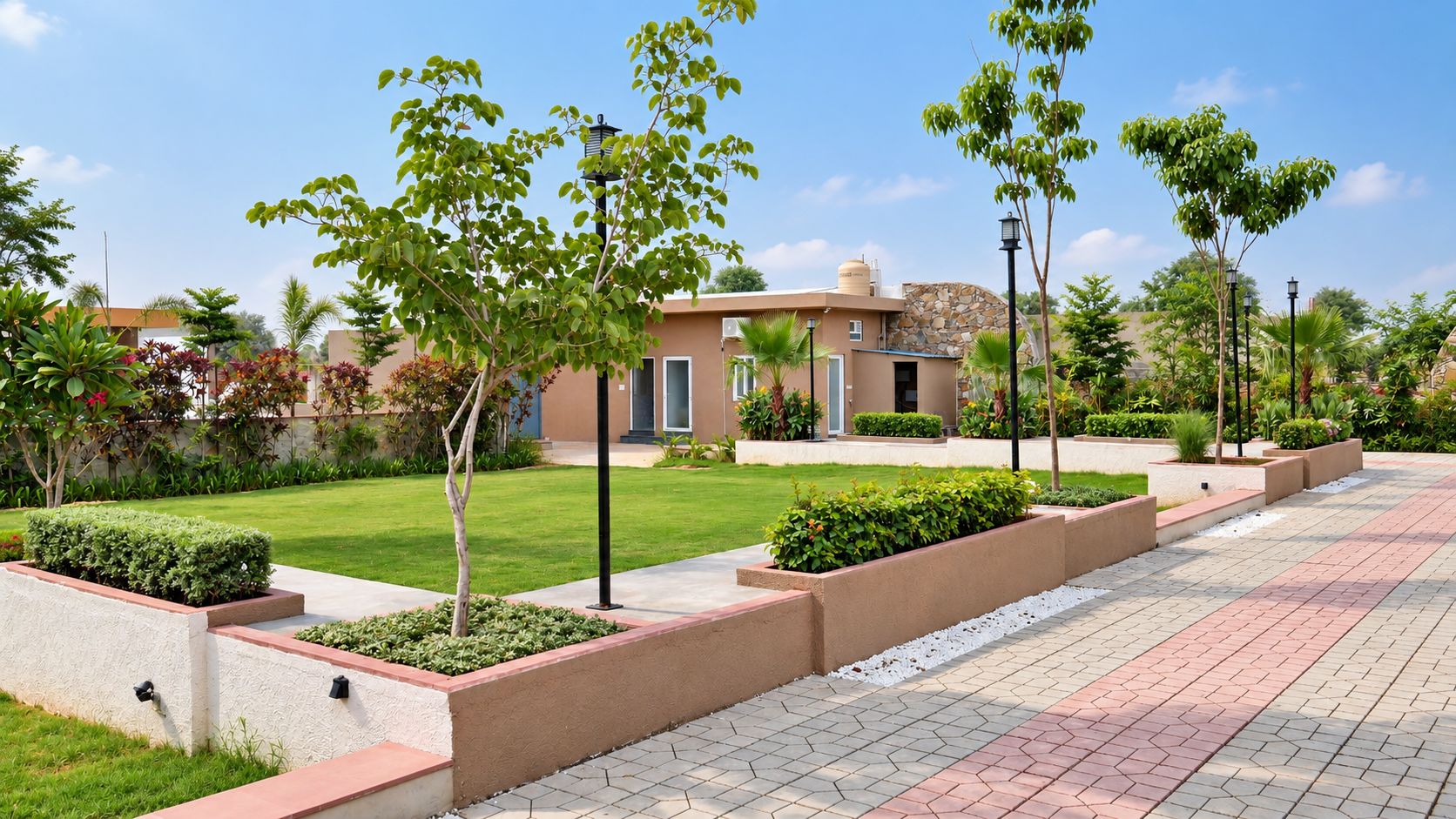 A landscaped pathway with planters and a building with a stone facade.