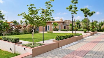 A landscaped pathway with planters and a building with a stone facade.