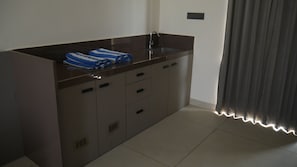 A modern bathroom with a dark countertop, a sink, and a towel rack. - Hunaariya Farms (Jaipur)
