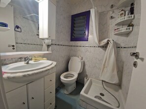 A bathroom with a white sink, toilet, and bathtub.