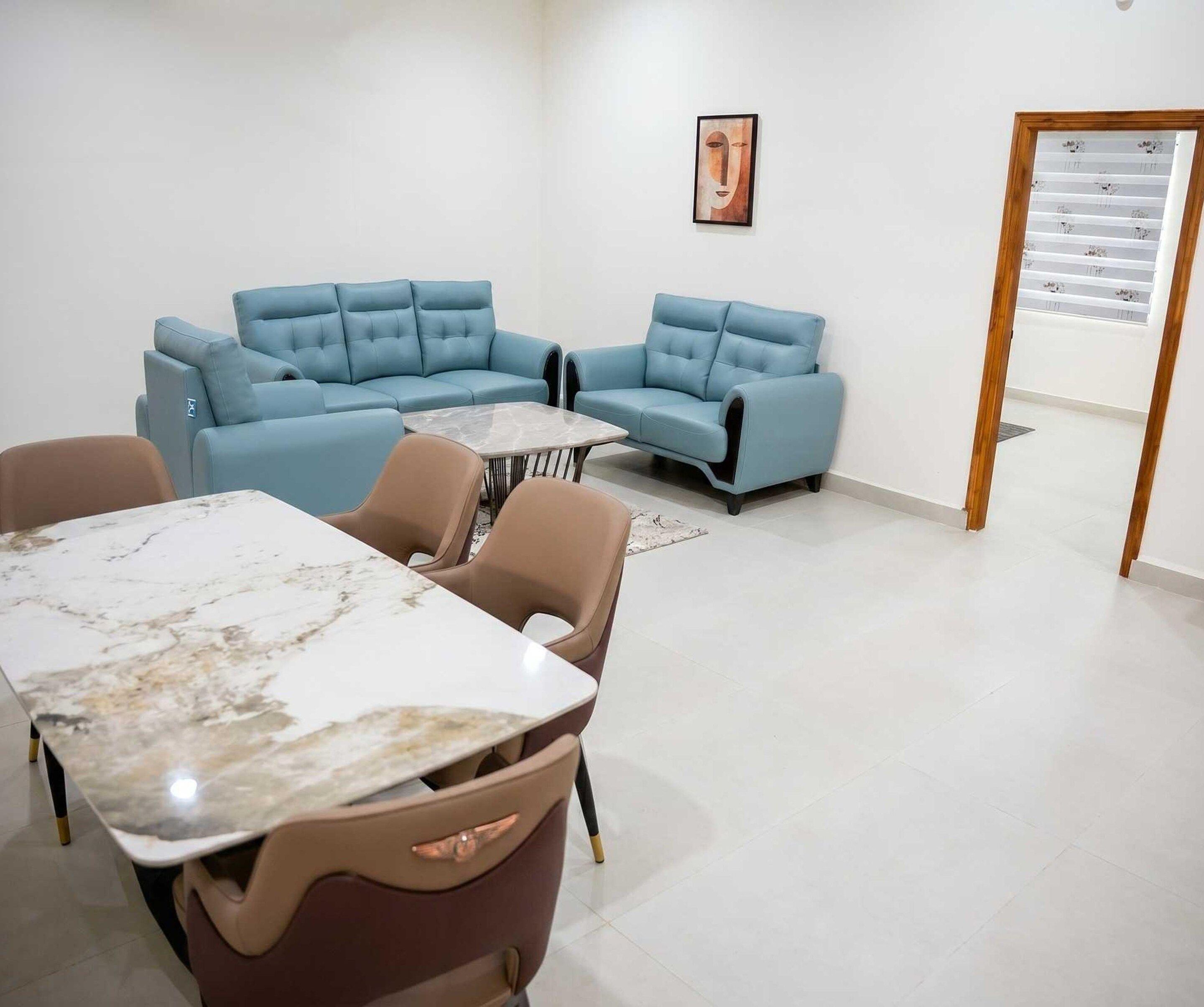 A modern living room with a sectional sofa, a dining table, and a small coffee table.