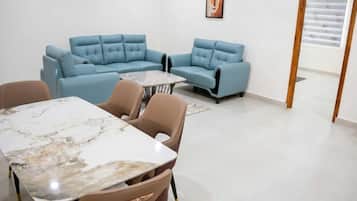 A modern living room with a sectional sofa, a dining table, and a small coffee table.