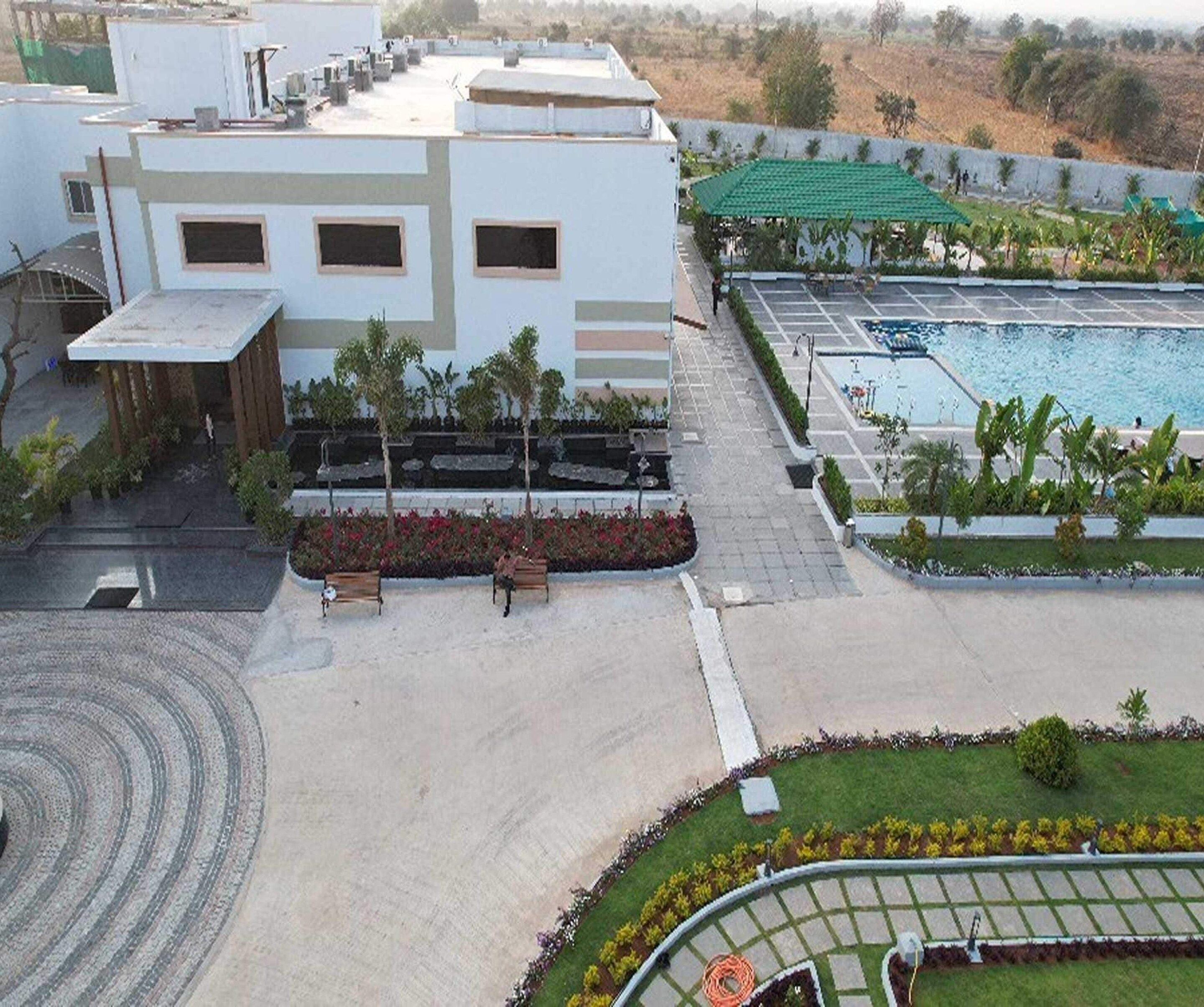 A modern building with a rooftop pool and a landscaped garden area.