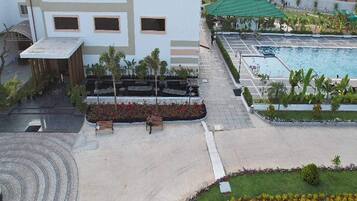 A modern building with a rooftop pool and a landscaped garden area.