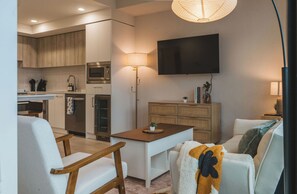 A modern living space with a kitchen, dining area, and seating.
