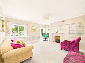 A spacious living room with a fireplace, a television, and comfortable seating. - Cheltenham Retreat | Luxury | Garden | Sleeps 11 (Charlton Kings)