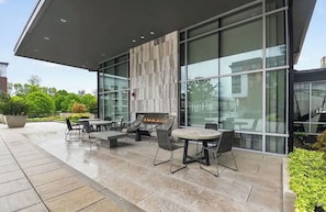 Un patio al aire libre con mobiliario y una chimenea.